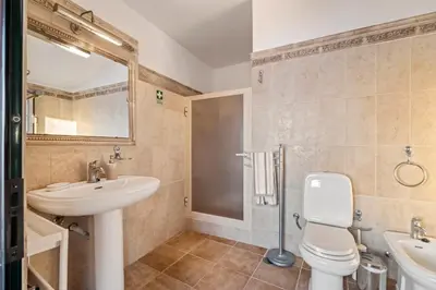 a bathroom with a sink and a toilet and a shower at Ocean View Eiras Cottage II in Fajã da Ovelha