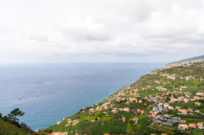 an aerial view of a town on a hill next to the ocean at Ana's View, cozy apartment, AC, sea view & parking in Arco da Calheta