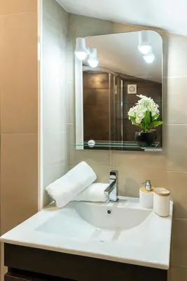 a bathroom with a white sink and a mirror at Ana's View, cozy apartment, AC, sea view & parking in Arco da Calheta
