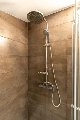a shower with a shower head in a bathroom at Ana's View, cozy apartment, AC, sea view & parking in Arco da Calheta