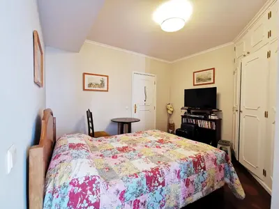 a bedroom with a bed and a flat screen tv at NewCastle in Funchal