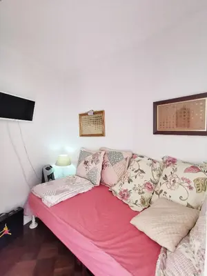 a couch with pink sheets and pillows in a room at NewCastle in Funchal