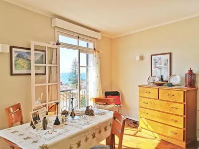 a room with a table with a dresser and a window at NewCastle in Funchal