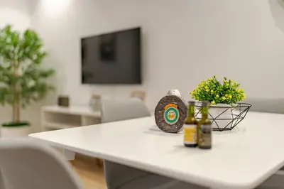 a white table with two bottles and flowers on it at Vienna apartment Alpine escape villa in Gaula