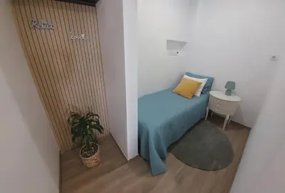 a small bedroom with a bed and a plant at Apartment Studio Espiche near Praia da Luz in Luz