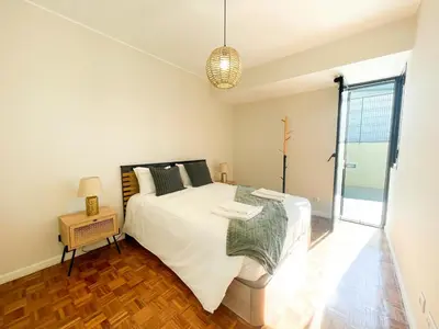 a bedroom with a large white bed and a window at Flor do Lido in Funchal