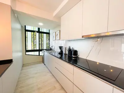 a kitchen with white cabinets and black counter tops at Flor do Lido in Funchal