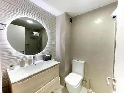 a bathroom with a toilet and a sink and a mirror at Flor do Lido in Funchal