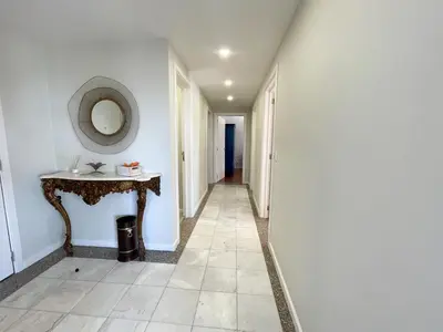 a hallway with a table and a mirror on a wall at Flor do Lido in Funchal
