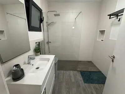 a white bathroom with a sink and a shower at LOV - Lombadinha Ocean View in Gaula