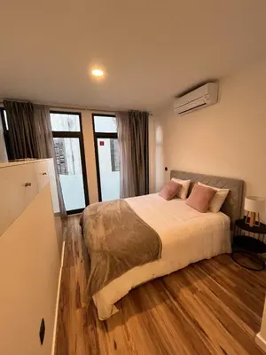 a bedroom with a large bed and some windows at Private 1 bedroom house in Machico Centre in Machico