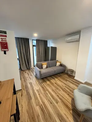 a living room with a couch and a wooden floor at Private 1 bedroom house in Machico Centre in Machico