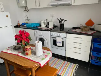 a kitchen with a table and a stove top oven at La casita de campo in Ponta do Sol