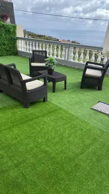 a group of chairs and tables on a green lawn at La casita de campo in Ponta do Sol