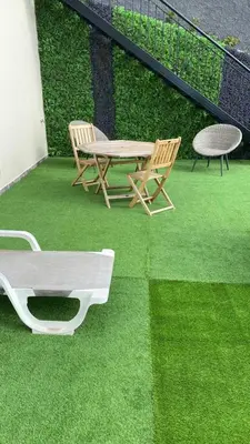 a patio with two chairs and a table on grass at La casita de campo in Ponta do Sol