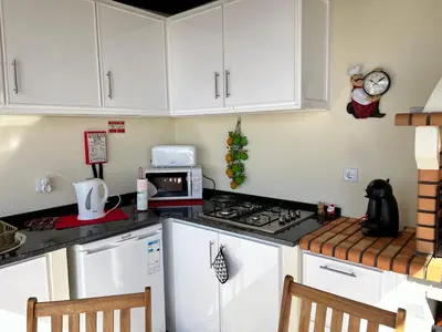 a kitchen with white cabinets and a stove top oven at La casita de campo in Ponta do Sol