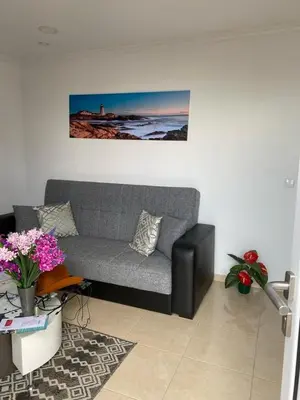 a living room with a gray couch and a table at La casita de campo in Ponta do Sol
