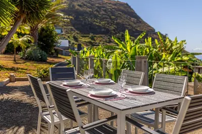 a table with chairs and plates and glasses on it at Calheta Traditional in Arco da Calheta