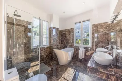 a bathroom with a shower and two sinks and a tub at Calheta Traditional in Arco da Calheta