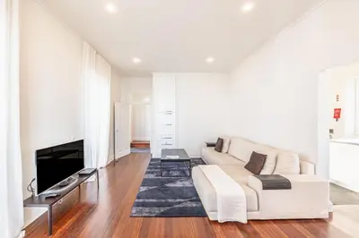 a living room with a white couch and a tv at Calheta Traditional in Arco da Calheta