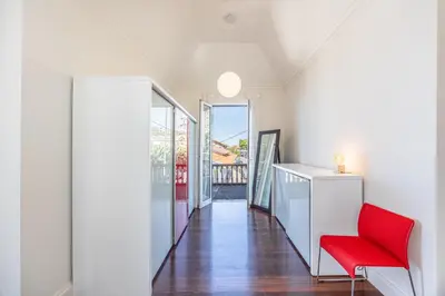 a living room with a red chair and a hallway at Calheta Traditional in Arco da Calheta