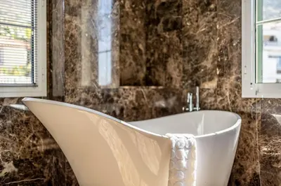 a bath tub in a bathroom with a mirror at Calheta Traditional in Arco da Calheta