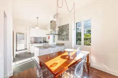 a kitchen with a wooden table and chairs in it at Calheta Traditional in Arco da Calheta