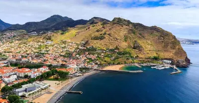 an aerial view of a town on a hill next to the ocean at Holiday Beach in Machico