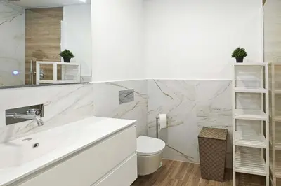 a white bathroom with a sink and a toilet at Holiday Beach in Machico