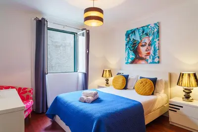 a bedroom with a bed with a blue blanket at GuestReady - Breathtaking seaview in Caniço in Caniço