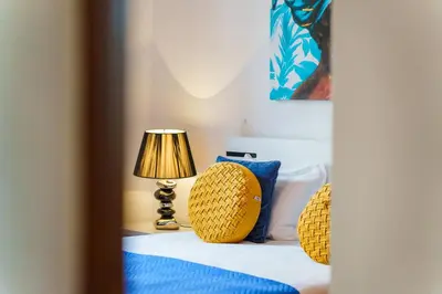 a bedroom with a bed with a lamp and blue pillows at GuestReady - Breathtaking seaview in Caniço in Caniço