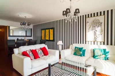 a living room with two white couches and striped walls at GuestReady - Breathtaking seaview in Caniço in Caniço