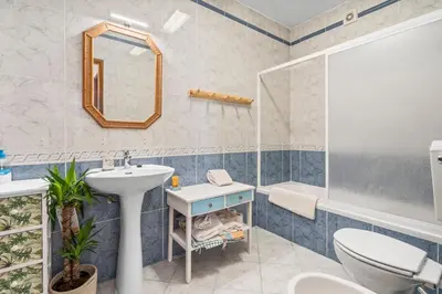 a bathroom with a sink and a toilet and a mirror at Burgau Fisherman's Cottage in Burgau
