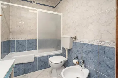 a bathroom with a toilet and a shower and a sink at Burgau Fisherman's Cottage in Burgau