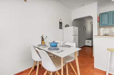a kitchen with a white table and white chairs at Casa Indie in Burgau