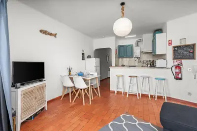 a living room with a kitchen with a table and chairs at Casa Indie in Burgau