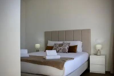 a bedroom with a large white bed with two lamps at Like Home I - vista mar e ambiente relaxante in Funchal