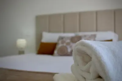 a bedroom with a bed with white sheets and pillows at Like Home I - vista mar e ambiente relaxante in Funchal