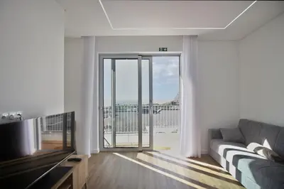 a living room with a couch and a large window at Like Home I - vista mar e ambiente relaxante in Funchal