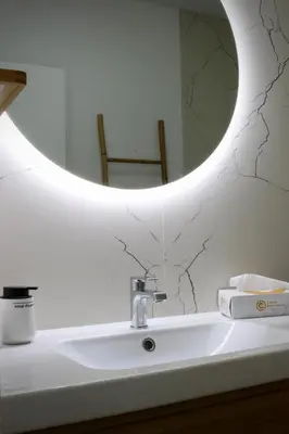 a bathroom with a sink with a round mirror at Like Home II - casa espaçosa com 3 quartos e vista mar in Funchal