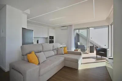 a living room with a gray couch and yellow pillows at Like Home II - casa espaçosa com 3 quartos e vista mar in Funchal