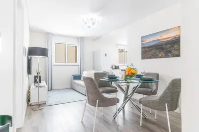 a living room with a table and chairs at Funchal Essence by Atlantic Holiday in Funchal