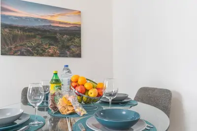 a table with a bowl of fruit and wine glasses at Funchal Essence by Atlantic Holiday in Funchal