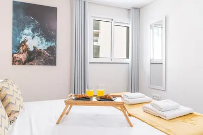 a living room with a table and glasses of orange juice at Funchal Essence by Atlantic Holiday in Funchal