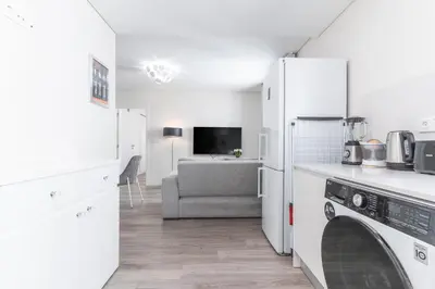 a kitchen with a refrigerator and a living room at Funchal Essence by Atlantic Holiday in Funchal