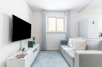 a living room with a couch and a flat screen tv at Funchal Essence by Atlantic Holiday in Funchal