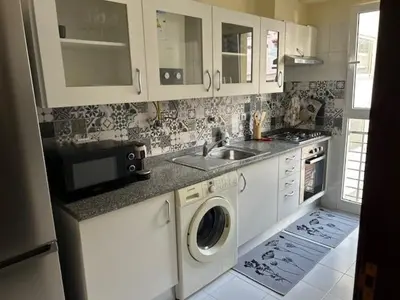 a kitchen with a sink and a washing machine at Caniço Easy Stay in Caniço