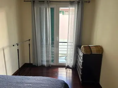 a bedroom with a bed and a sliding glass door at Caniço Easy Stay in Caniço