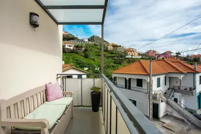 a balcony with a bench and a view of a city at Apartamento Eden in Machico
