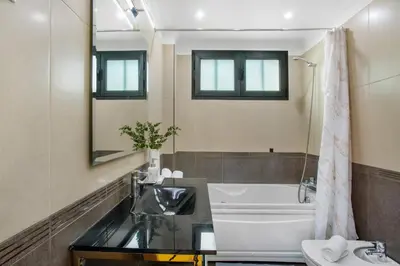 a bathroom with a sink and a tub and a mirror at Apartamento Eden in Machico